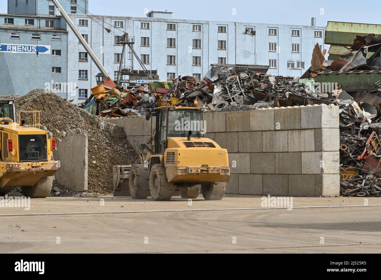 Basel, Schweiz - April 2022: Ein mechanischer Bagger arbeitet auf einer Altmetall-Recycling-Werft im Hafengebiet der Stadt. Stockfoto