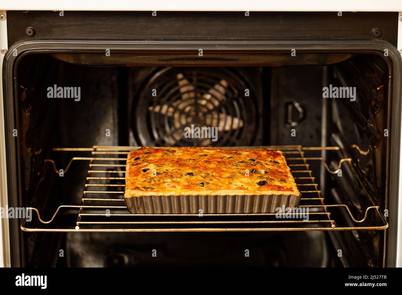 Hausgemachte kitschige Quiche mit Tomaten, Champignons und Oliven im heimischen Ofen gebacken. Geringer Fokus. Stockfoto
