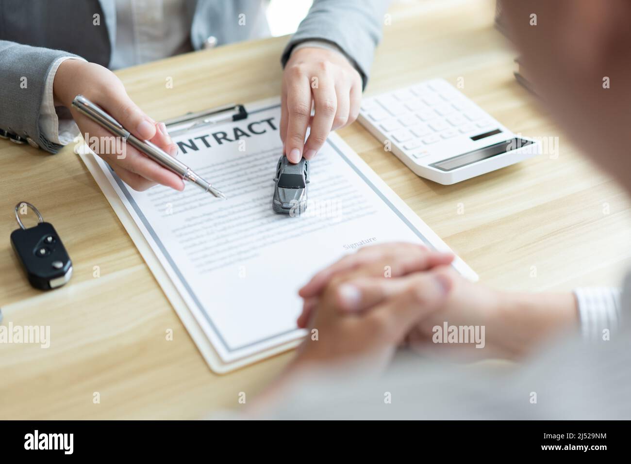 Versicherungskonzept der Autovermittler unterstützt seinen Kunden und erklärt die Details des Autokontakts. Stockfoto