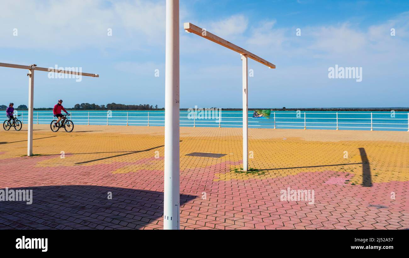 Das junge Paar radelt an einem sonnigen Tag entlang des Paseo de la Ría del Río Odiel in Huelva. Stockfoto