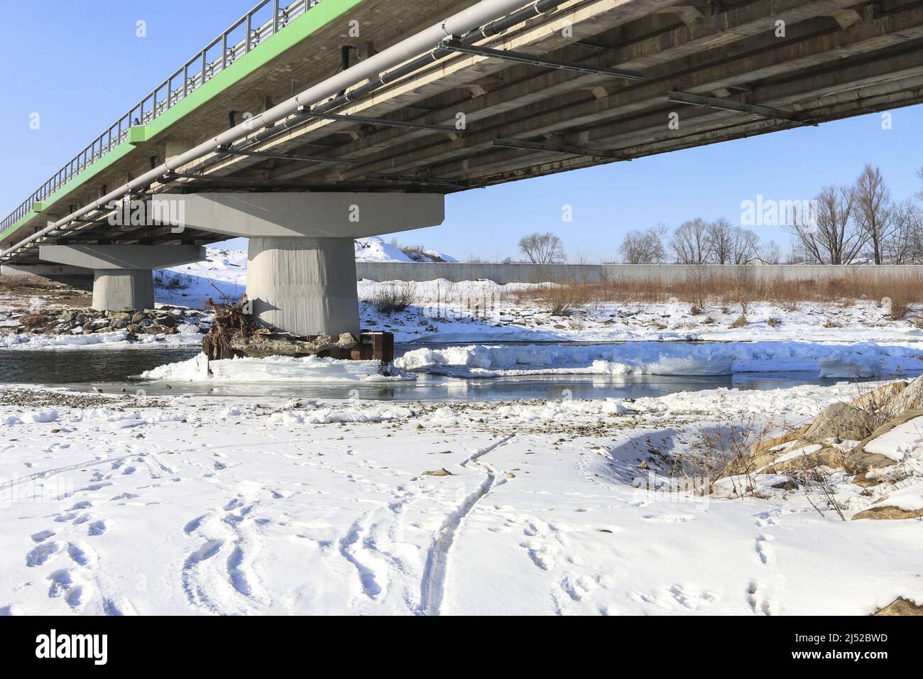 Brückenpfeiler mit Eis bedeckt, gefrorener Fluss. Winterzeit Stockfoto