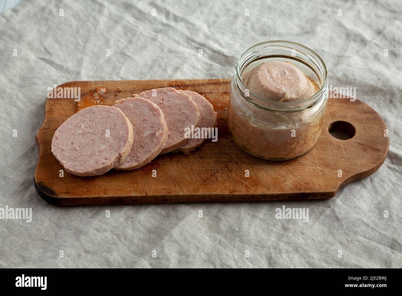 Hausgemachter Jagdwurst auf rustikalem Holzbrett, Blick aus der unteren Ecke. Stockfoto