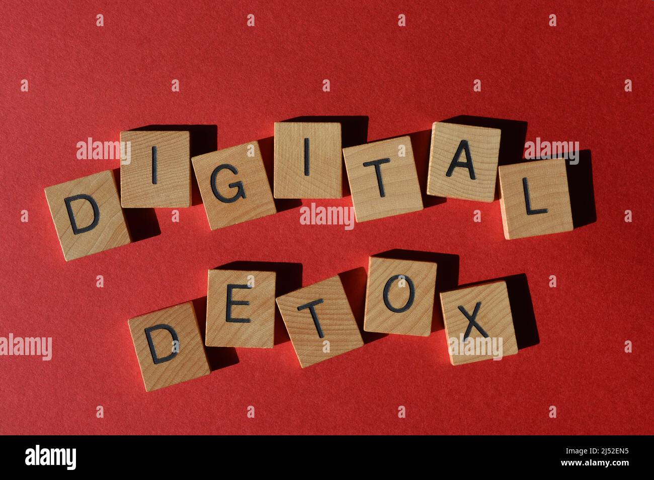 Digital Detox, Wörter in Holzbuchstaben isoliert auf hellrotem Hintergrund Stockfoto