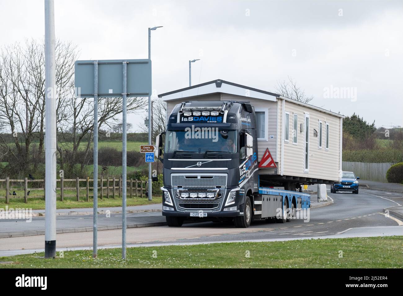 Ein LKW, der eine breite Ladung auf einer britischen A-Straße transportiert, ist abgebildet. Die abnorme oder breite Last ist ein Wohnmobil, das auf der Straße zu einem neuen Ziel gebracht wird Stockfoto