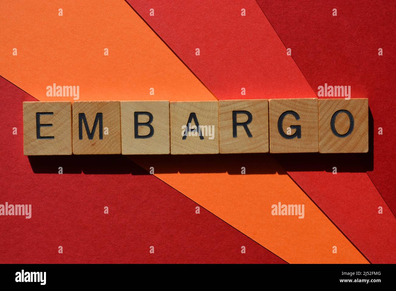 Embargo, Wort in Holzbuchstaben isoliert auf rotem und orangefarbenem Hintergrund Stockfoto