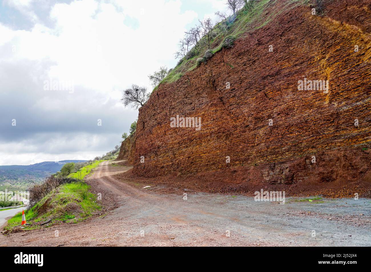 Traditionelle Landschaft in Zypern mit einer braunen, fein geschichteten Kalksteinklippe im Vordergrund Stockfoto