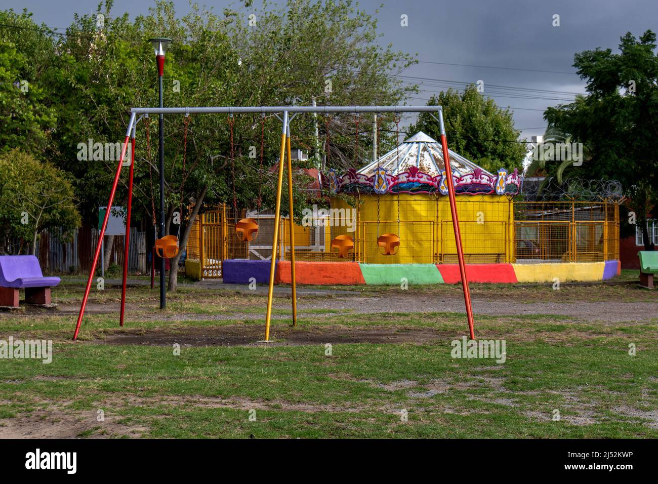 Blick auf Babyschaukeln und Karussell, in leerem Park Stockfoto