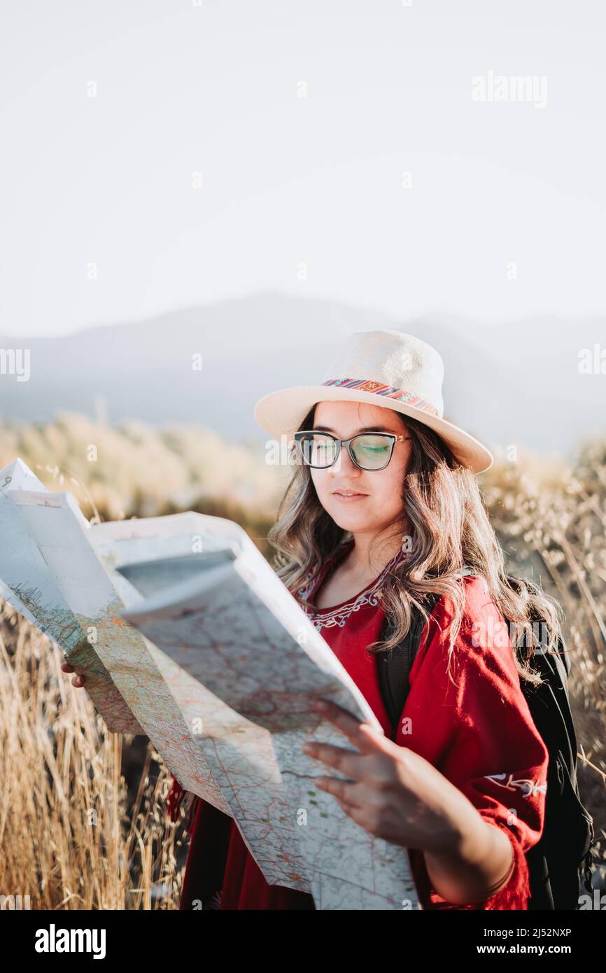 Junge Reisende Frau trägt einen Hut, mit einem Rucksack auf, überprüfen Sie die Karte während der Wanderung, um die Natur zu erkunden. Stockfoto