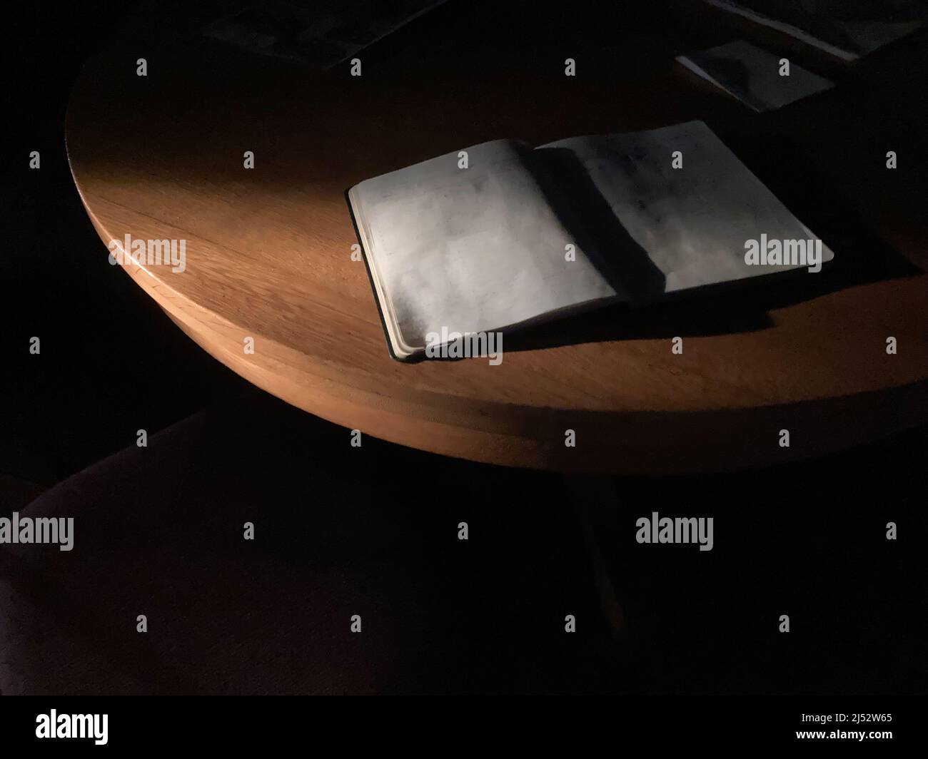 Wunderschönes, dramatisches Licht am frühen Morgen und ein leeres Tagebuch auf dem Tisch Stockfoto
