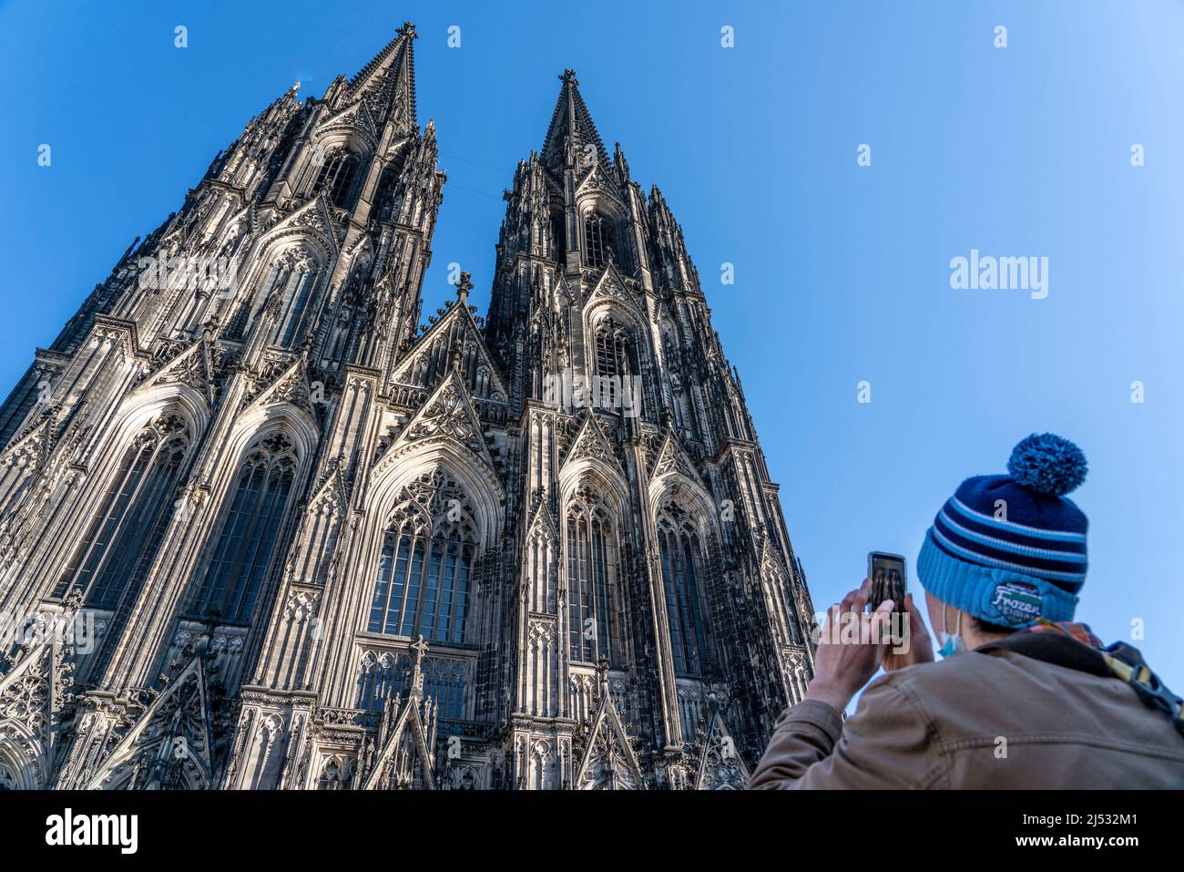 Kölner Dom, Blick auf die Westfassade, am Nordturm, Tourist fotografiert mit Handy, Köln, Deutschland, Stockfoto