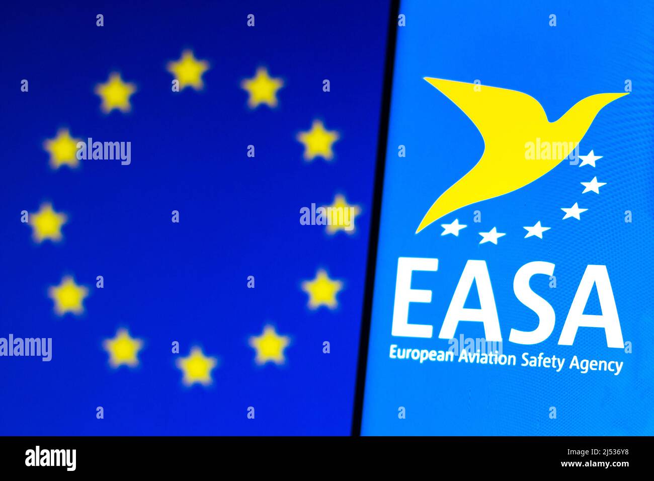 In dieser Abbildung ist das Logo der Europäischen Agentur für Flugsicherheit (EASA) auf einem Smartphone und im Hintergrund die Flagge der Europäischen Union (EU) zu sehen. Stockfoto