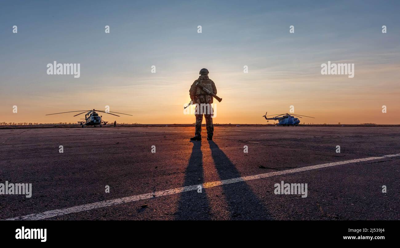 Mariupol, Ukraine. 16.. November 2017. Silhouette eines Militärs mit einem Maschinengewehr in einem Kampfposten gegen die Hubschrauber und Sonnenuntergang Himmel während der Feierlichkeiten anlässlich des Tages der Naval Infantry. (Bild: © Mykhaylo Palinchak/SOPA Images via ZUMA Press Wire) Stockfoto