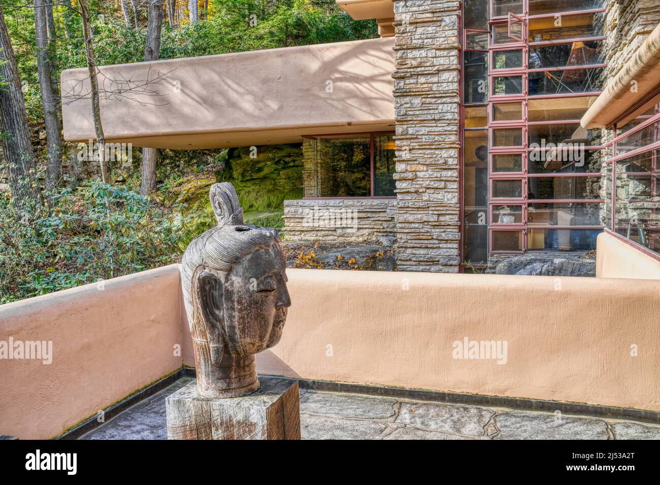Eine untere Terrasse mit der großen Buddha Head Skulptur bei Frank Lloyd Wrights Falling Water in Mill Run, Pennsylvania. Stockfoto