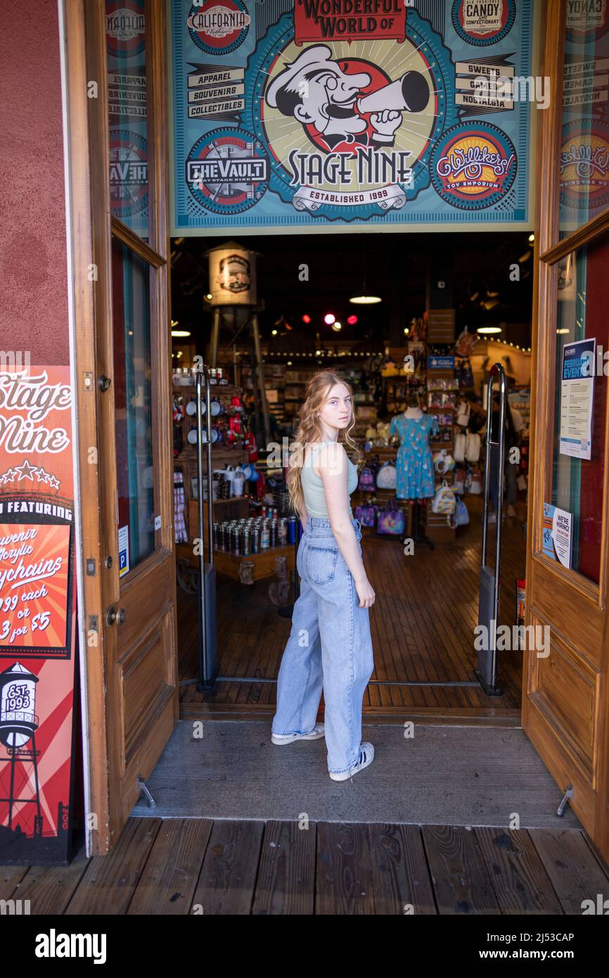 Junge Frau vor dem Einzelhandelsgeschäft in der Altstadt von Sacramento Stockfoto