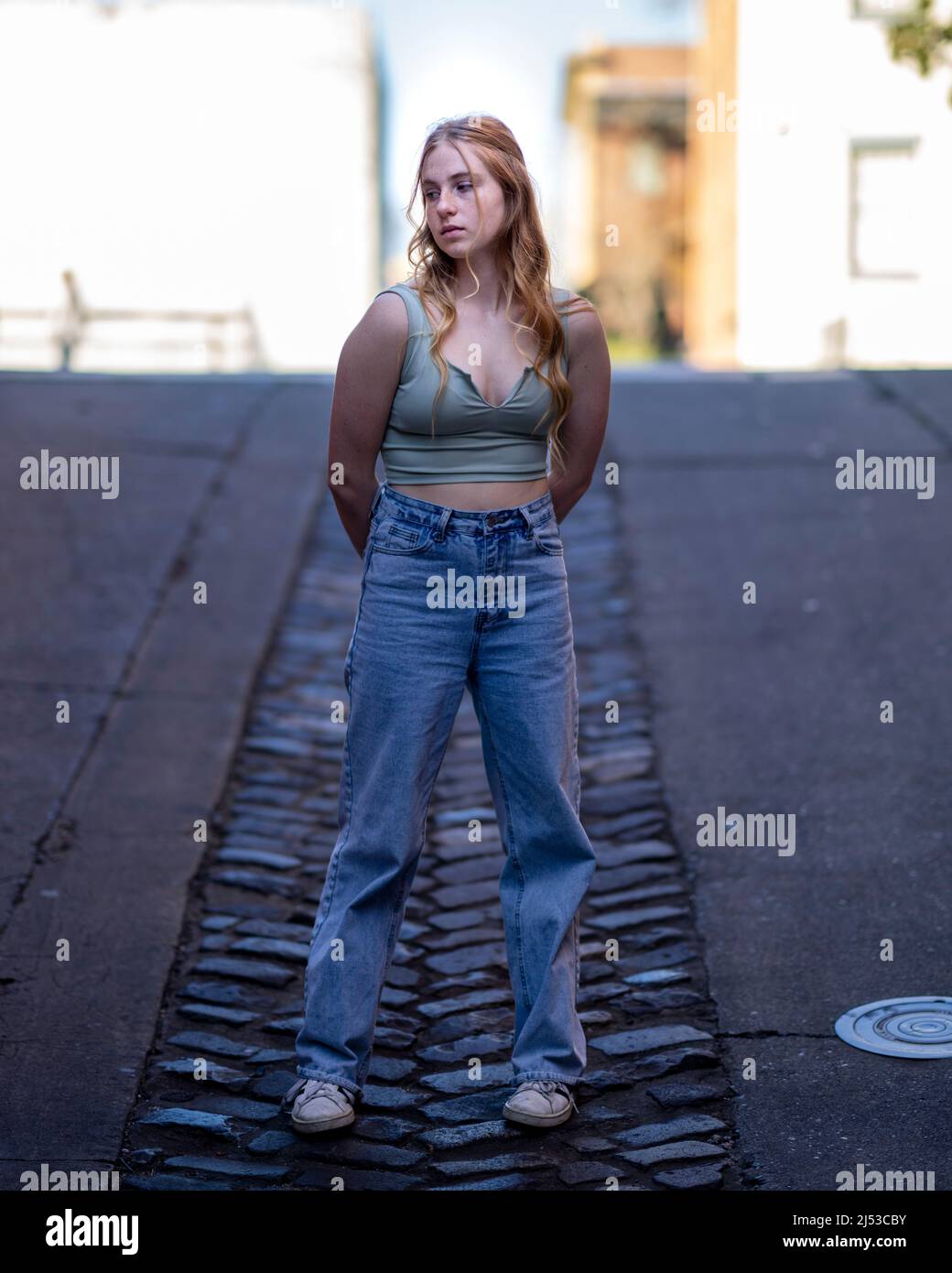 Junge Frau, die in der Gasse in der Altstadt von Sacramento steht Stockfoto