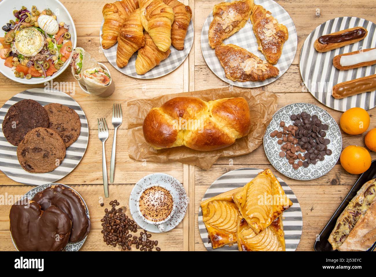 Draufsicht Bild von Desserts, Brioche Brot, Schokolade Palmen, Apfelkuchen, Cookies, Orangen, Buttercroissants und Salat Stockfoto