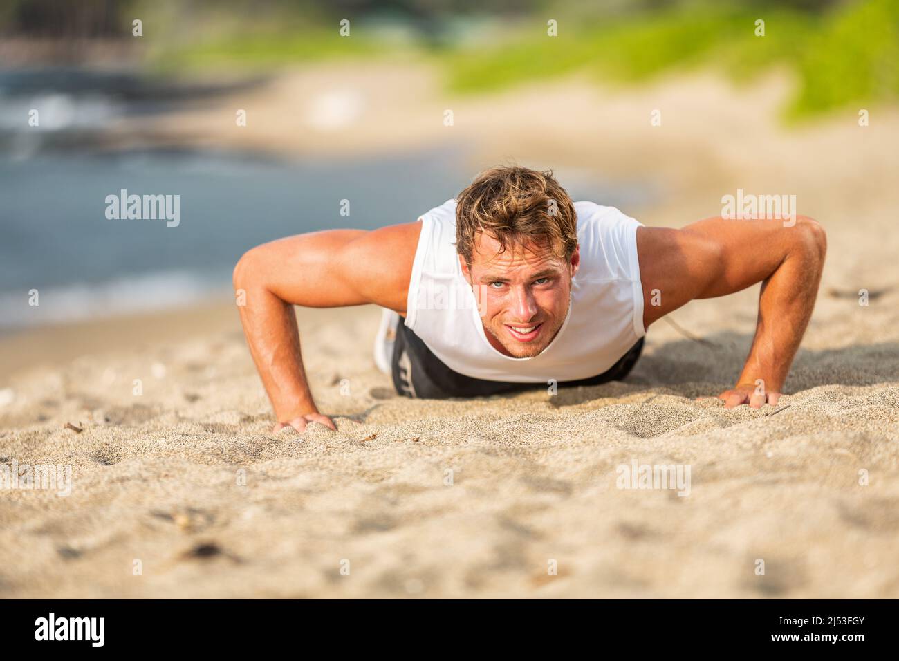 Fit Mann Athlet Training hart tun Liegestütze am Strand. Fitness-Motivation Stockfoto