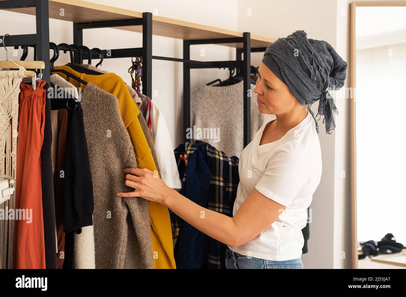 Eine Frau führt in ihrem Haus eine Kleideranalyse durch. Stockfoto