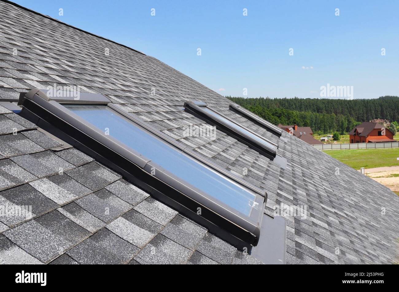 Dachfenster. Asphaltschindeln Haus Dachkonstruktion mit Dachfenstern, Dachfenster wasserdicht. Oberlichter. Stockfoto