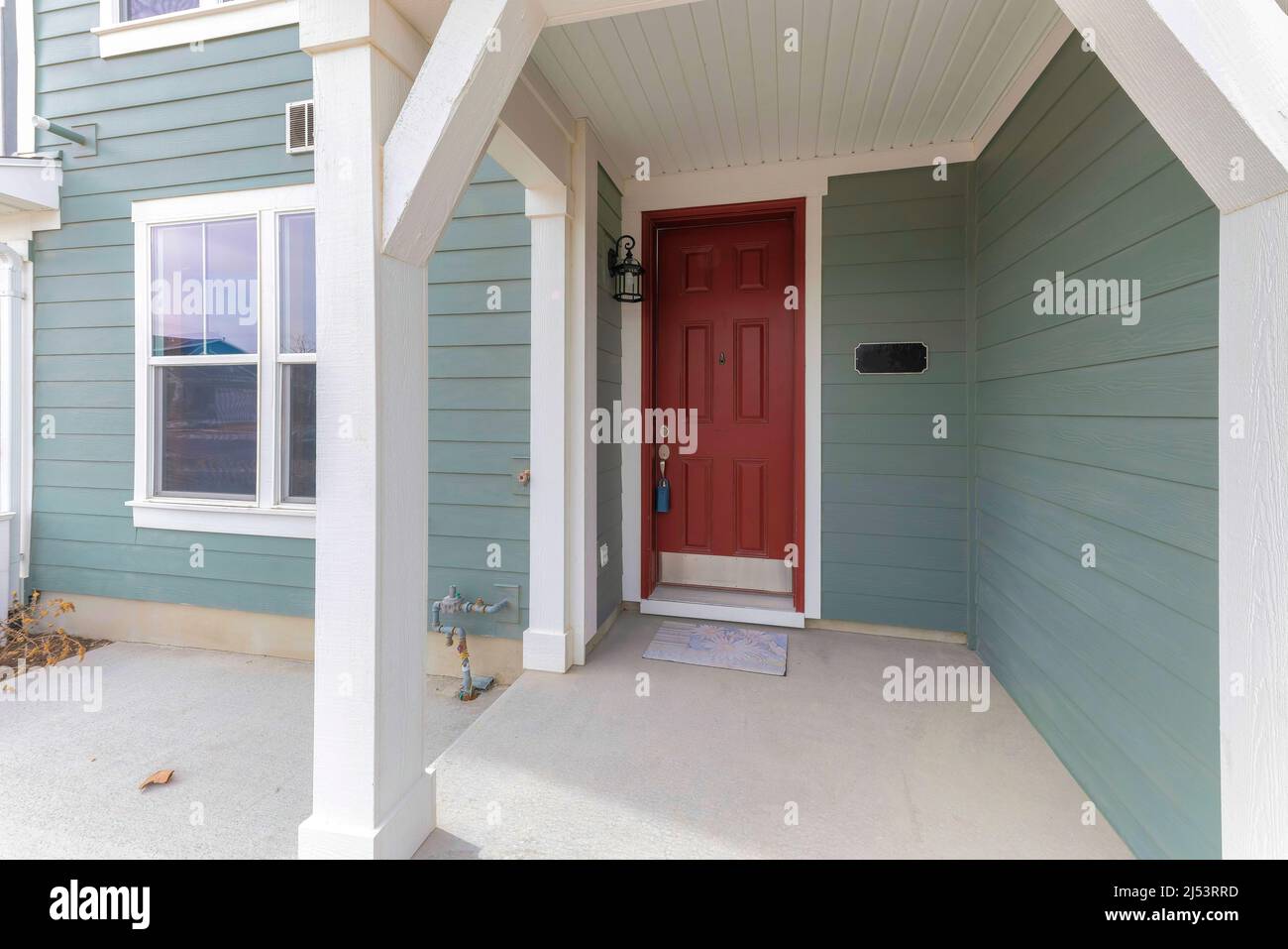 Townhouse Veranda mit Lockbox an der roten Haustür Stockfoto