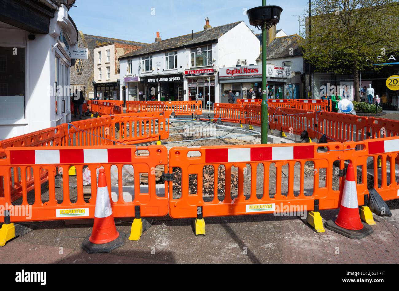 Straßenarbeiten, Bauarbeiten, Reparaturen und Graben von Löchern im Pfad, der von orangefarbenen Zäunen umgeben ist, in Littlehampton, West Sussex, England, Großbritannien. Stockfoto