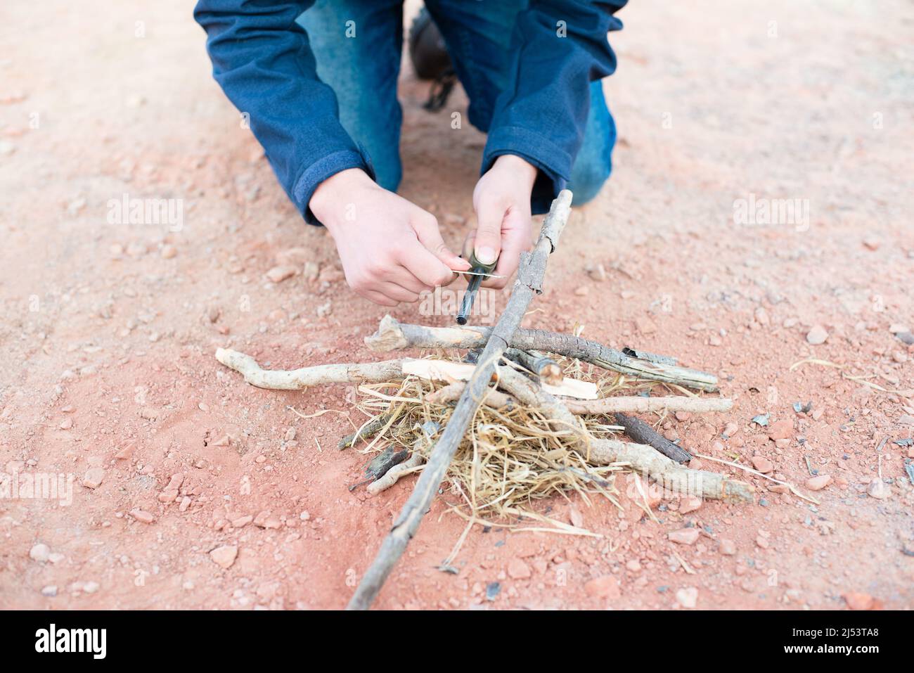 Ein Feuer mit einem Feuerstahl, Überlebens- und Abenteuerausrüstung, Outdoor-Fähigkeiten, Mann, der ein Lagerfeuer macht Stockfoto