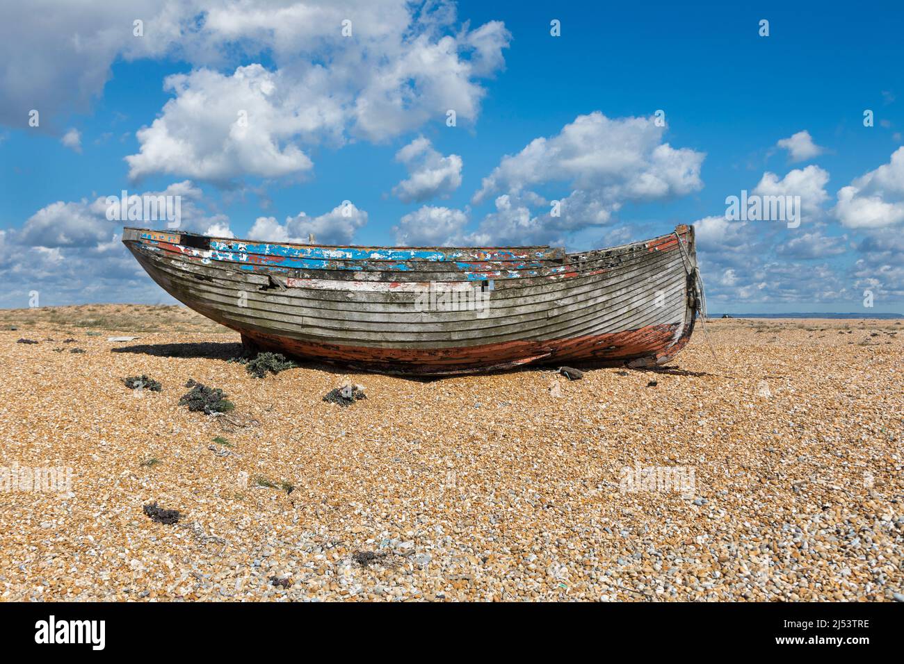 Ein altes verfallenes, verlassene Fischerboot aus Holz an einem Kiesstrand Stockfoto