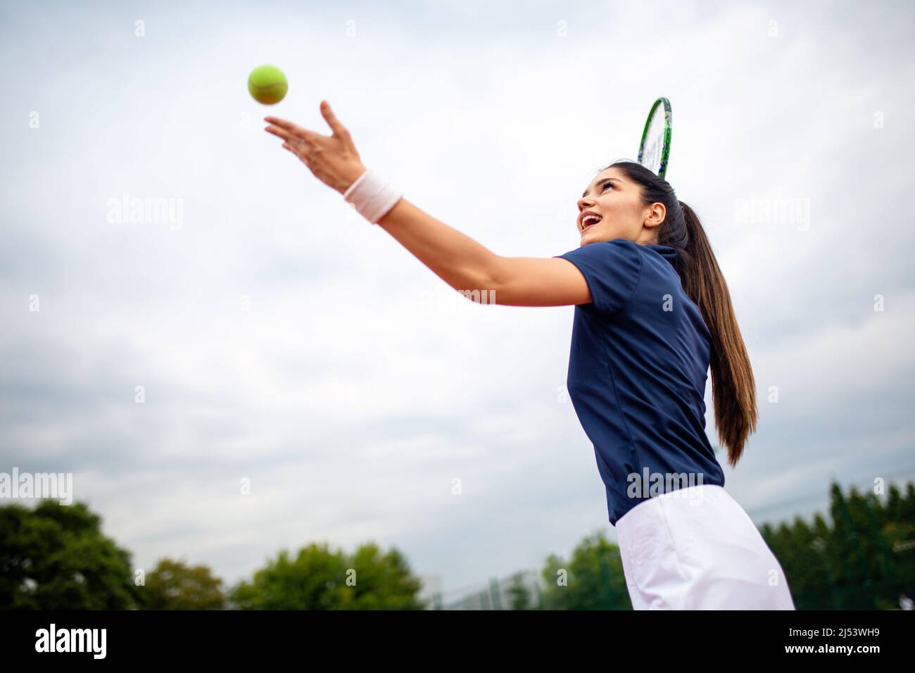 Junger, hübscher Tennisspieler mit Schläger und Ball bereitet sich auf den Beginn des Spiels oder Spiels vor. Stockfoto