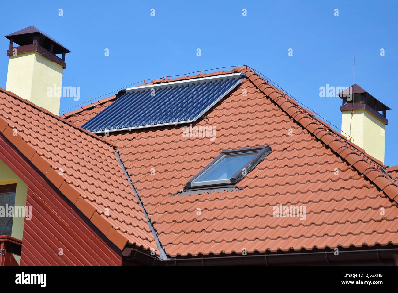 Keramik Dachziegel mit Dachfenster, Dachfenster, Solarpanel, Vakuum-Solarwasserheizung, Kamin und Blitzschutzsystem. Blitzschlag Stockfoto