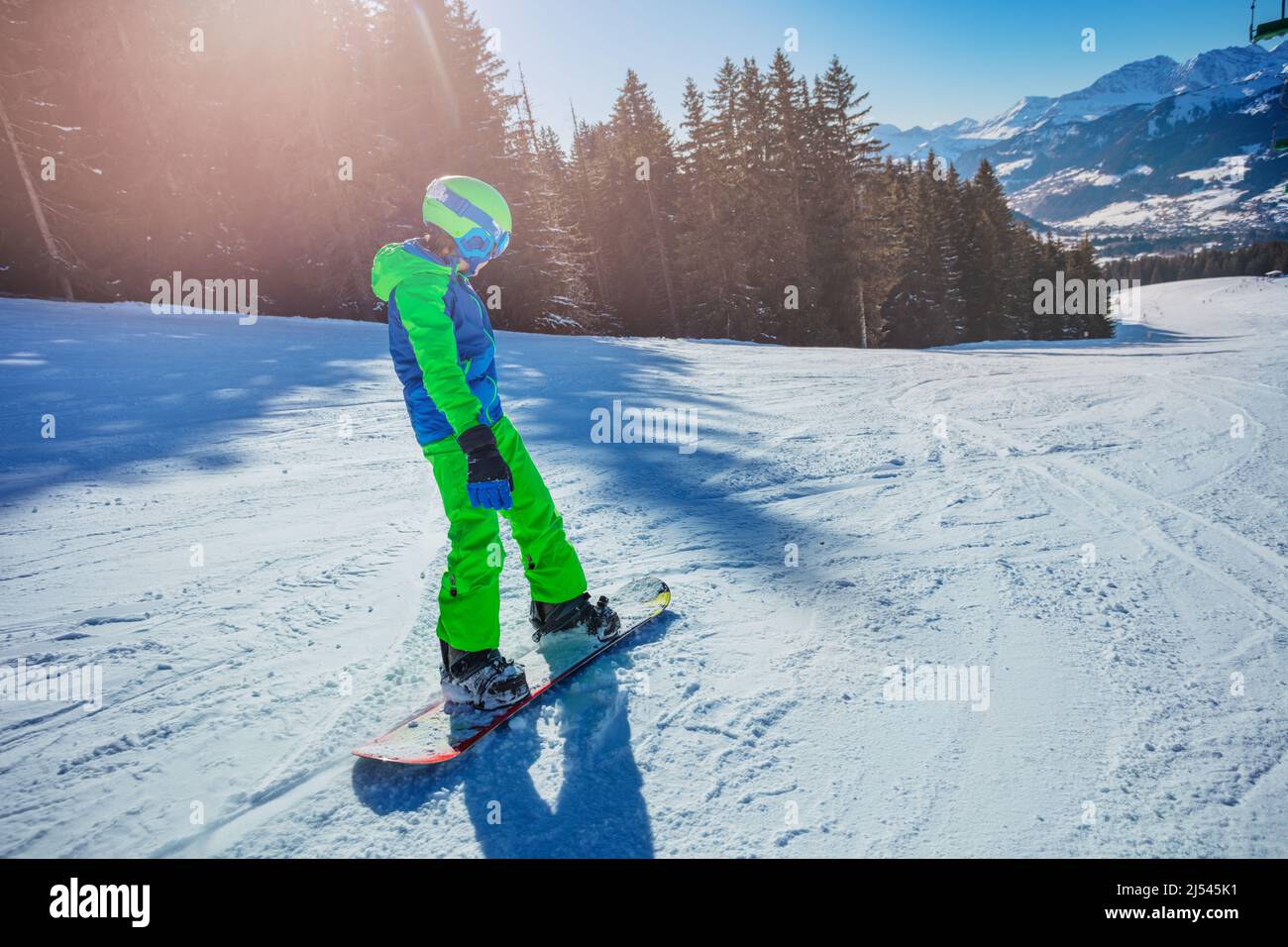 Boy slide schnell auf dem Snowboard vom Berg, Rückansicht Stockfoto