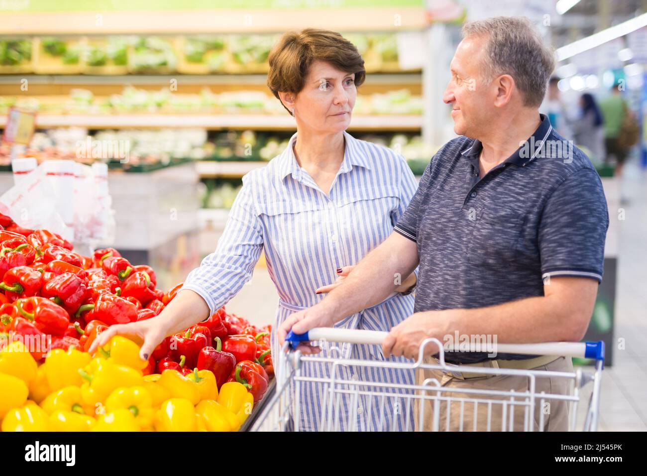 Ein älteres Paar kauft im alkoholischen Gemüse eines Supermarkts Paprika Stockfoto