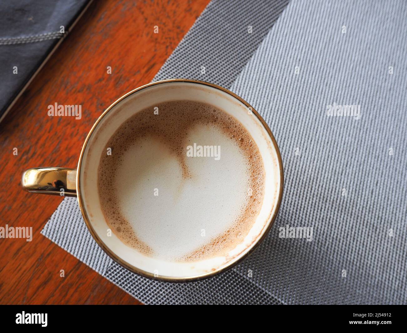 Nahaufnahme einer Tasse Kaffee von oben, die Latte-Kunst in Form eines Herzens zeigt Stockfoto