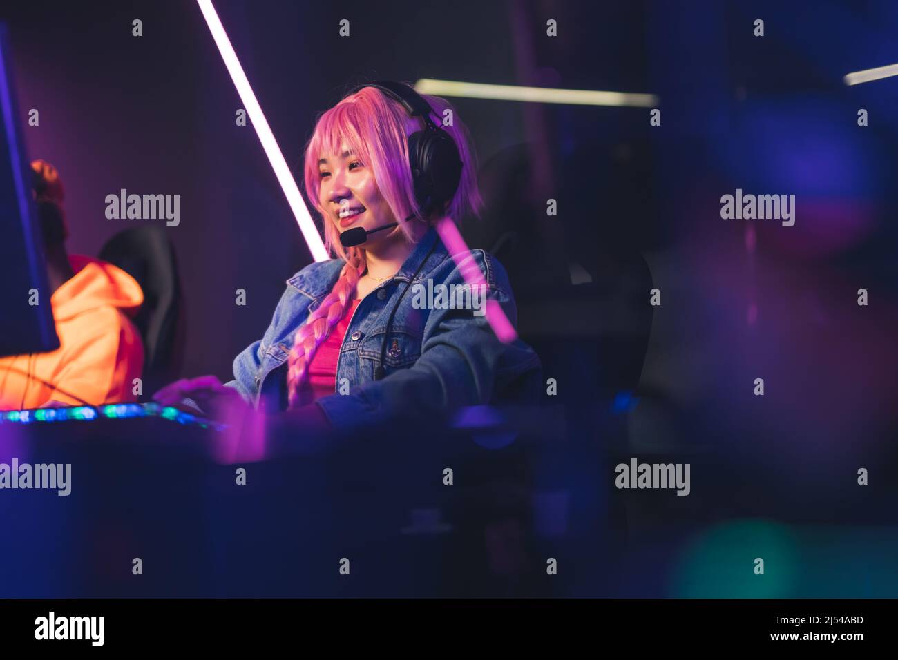 Schöne asiatische Frau in Kopfhörern spielen Videospiele dunklen Hintergrund kopieren Raum Konzept. Hochwertige Fotos Stockfoto