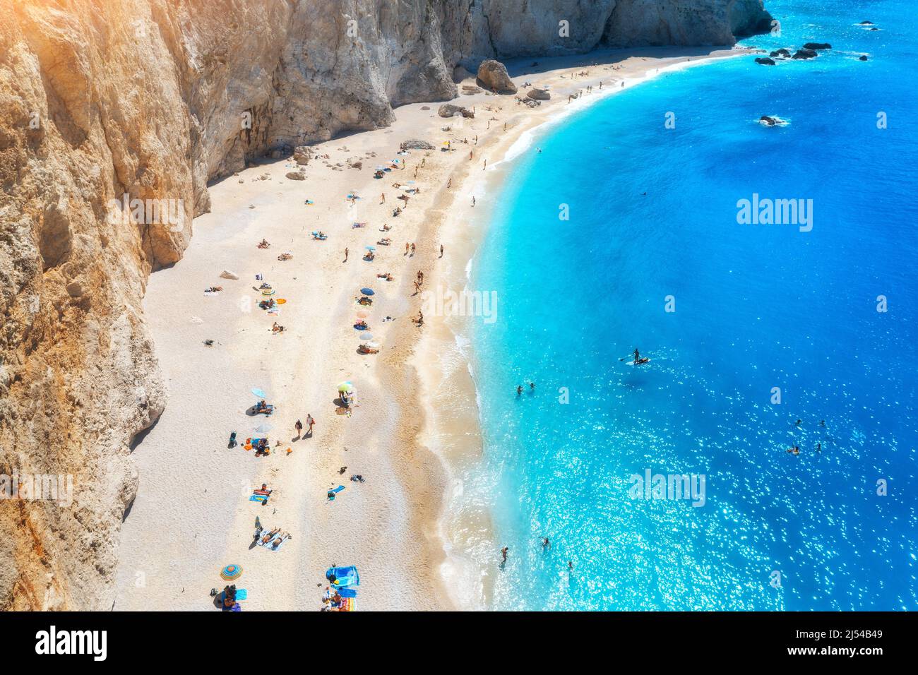 Luftaufnahme des blauen Meeres, Felsen, Sandstrand mit Sonnenschirmen Stockfoto