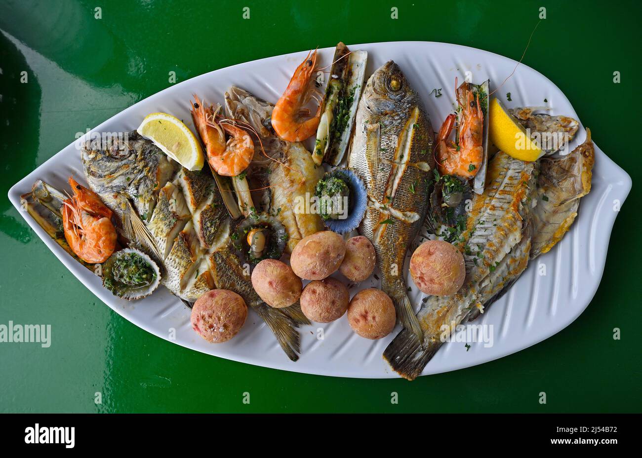 Typische Fischplatte mit verschiedenen gegrillten Fischen, Herzmuscheln, Rasiermuscheln, Garnelen, Kanarische Kartoffeln und Beilagen, Kanarische Inseln, Lanzarote Stockfoto