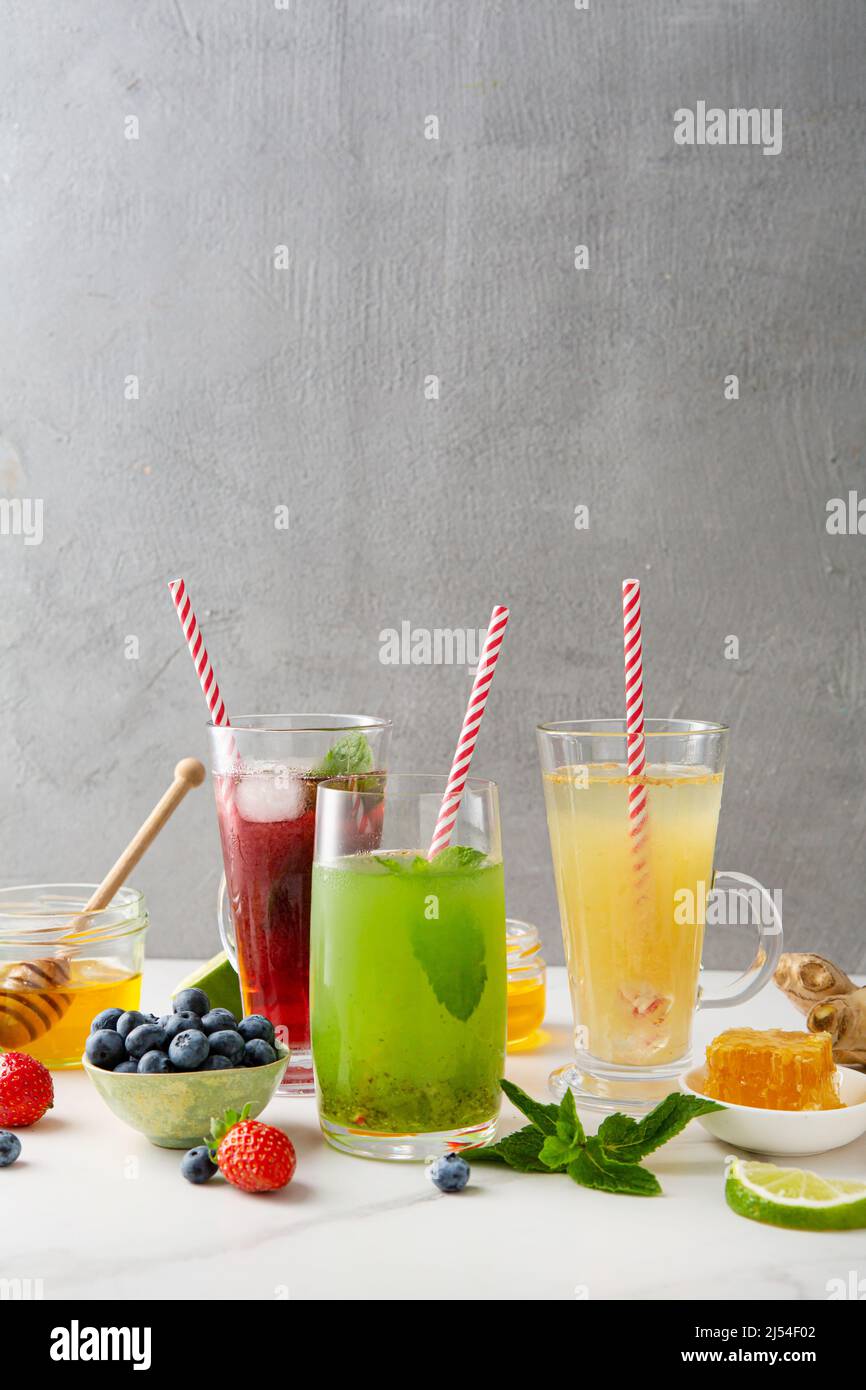 Sommerliche Frucht- und Beerengetränke mit Eislimonade auf heller Oberfläche Stockfoto