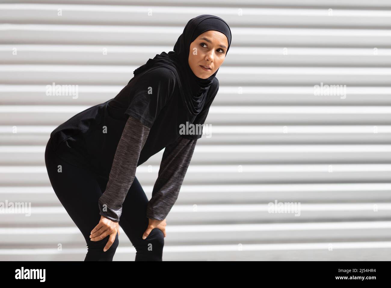 Müde tausendjährige islamische Frau in Hijab und Sportkleidung Ruhe nach dem Joggen Stockfoto