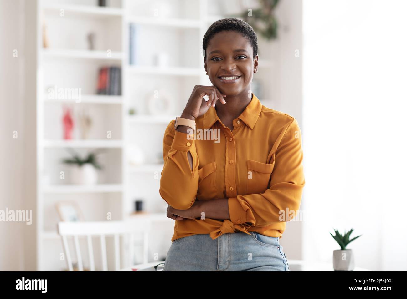 Erfolgreiche junge schwarze Geschäftsfrau posiert im Büro Stockfoto