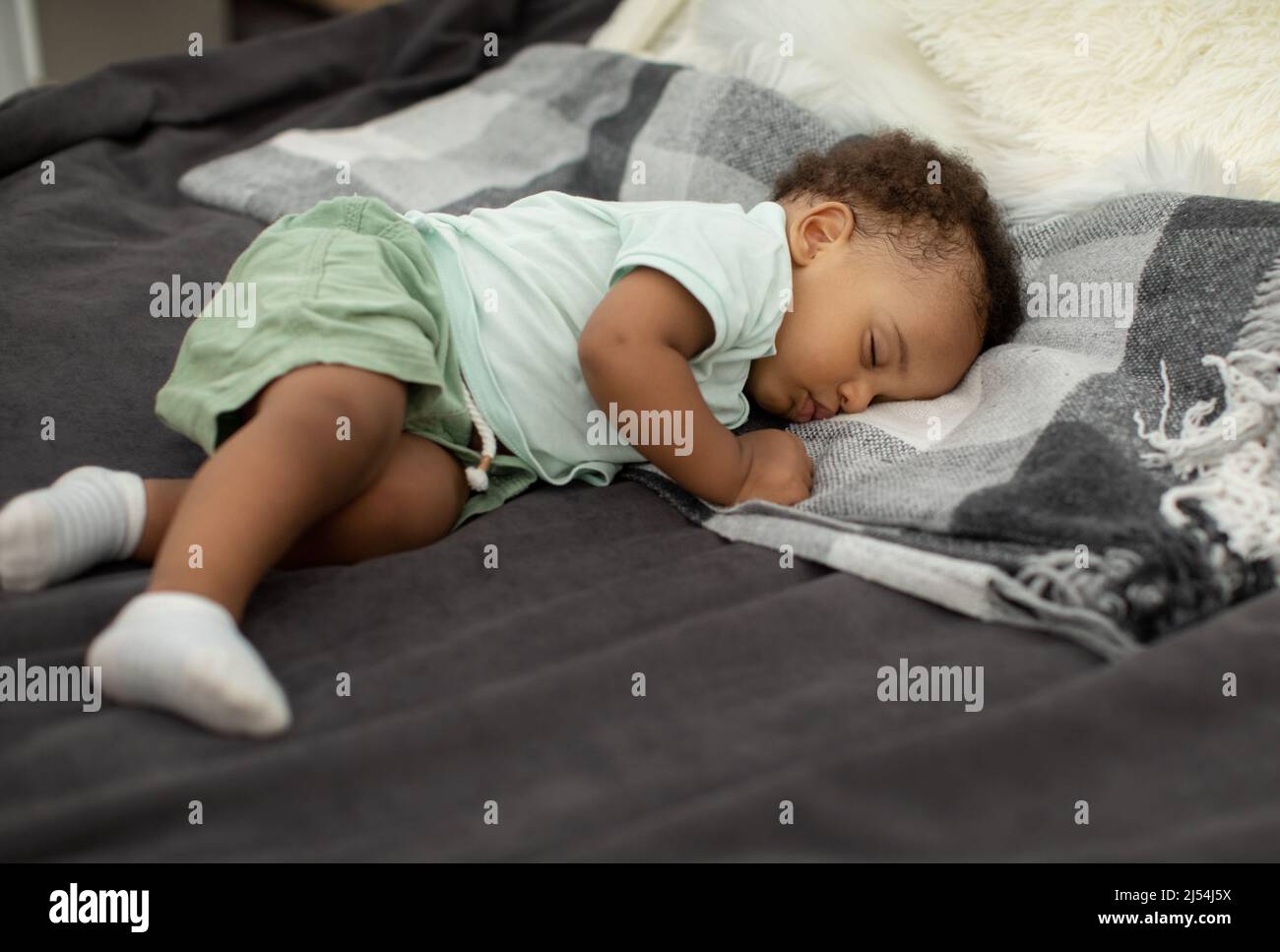 African American Baby Boy Schlafen Auf Seite Liegend Im Bett Stockfoto