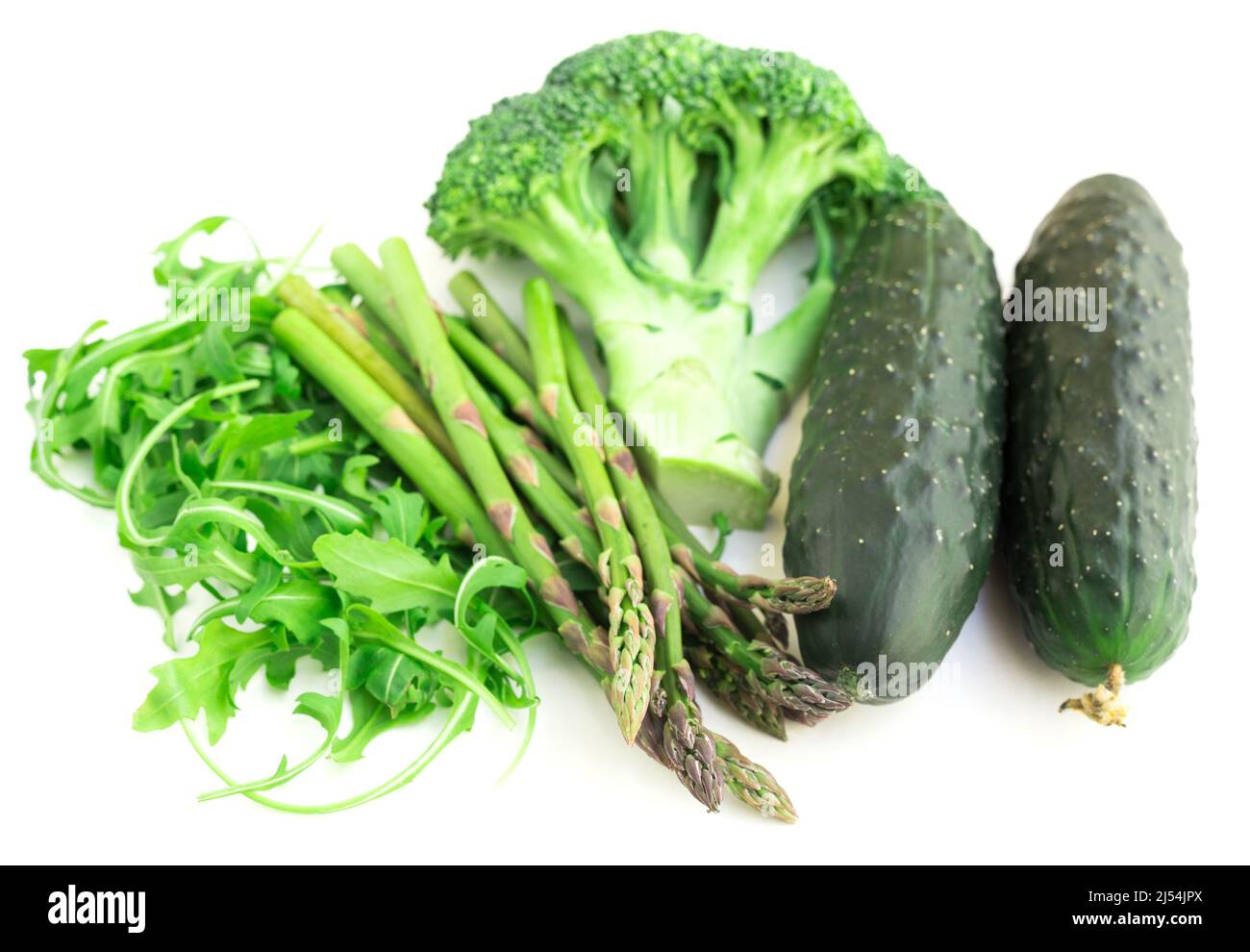 Stillleben von grünem Bauerngemüse, Rucola, Brokkoli, Spargel und Gurken auf weißem Hintergrund Stockfoto