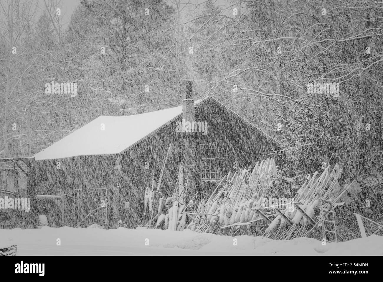 Ein gewerblicher Fischerstandort und Ausrüstung befinden sich während eines starken Schneefalls in der späten Saison in der Nähe von Baileys Harbor in Door County Wisconsin im Leerlauf. Stockfoto