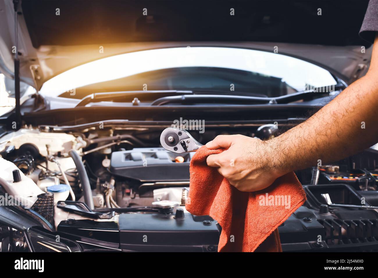 Auto Mechaniker Hand halten Schlüssel und roten Tuch zu reparieren Auto mit Auto Motor Hintergrund Stockfoto