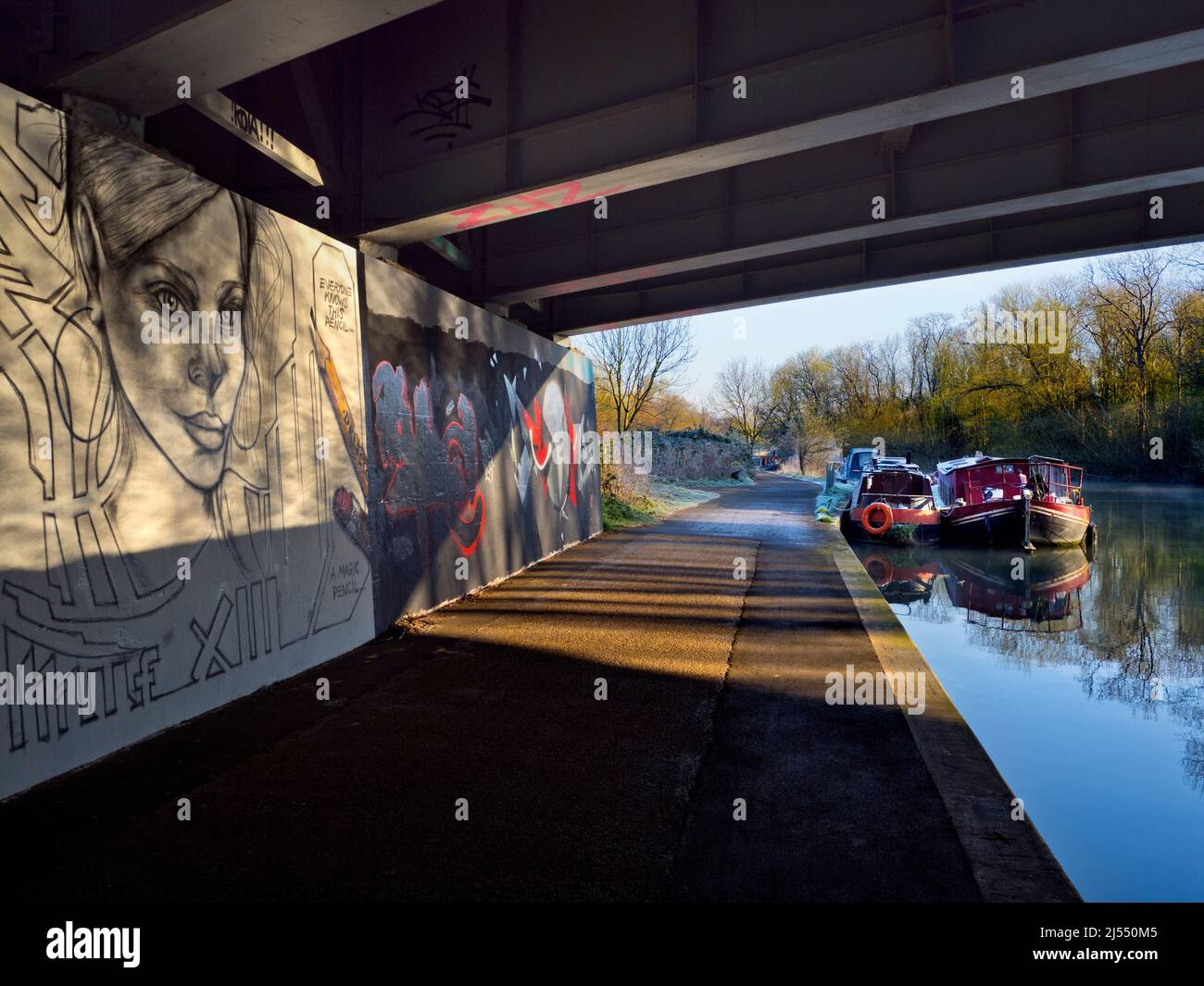 Kontraste. Dieses ruhige Bild von Booten, die an der Themse in der Nähe von Oxford festgemacht sind, zeigt nicht den Verkehr, der Tag und Nacht auf der Brücke vorbeifließt, Auto Stockfoto