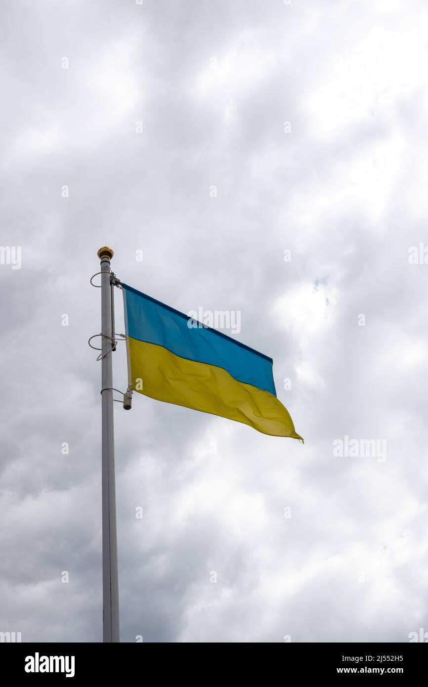 Ukrainische Bannerwelle auf dem Hintergrund des wolkigen, dramatischen Himmels. Foto am Tag, Himmel voller Wolken. Stockfoto
