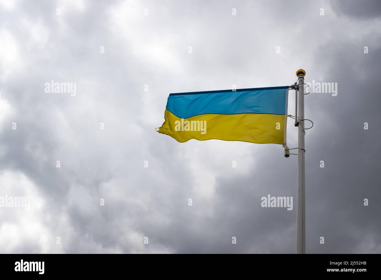 Ukrainische Bannerwelle auf dem Hintergrund des wolkigen, dramatischen Himmels. Foto am Tag, Himmel voller Wolken. Stockfoto