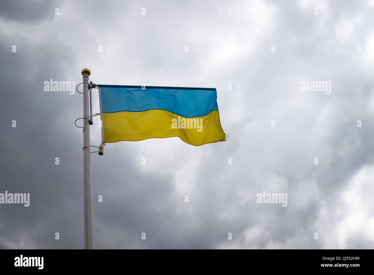 Ukrainische Bannerwelle auf dem Hintergrund des wolkigen, dramatischen Himmels. Foto am Tag, Himmel voller Wolken. Stockfoto