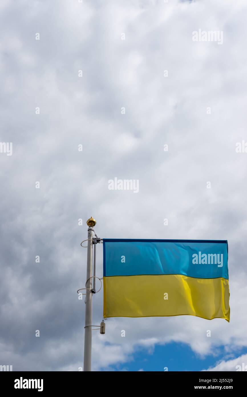 Ukrainische Bannerwelle auf dem Hintergrund des wolkigen, dramatischen Himmels. Foto am Tag, Himmel voller Wolken. Stockfoto