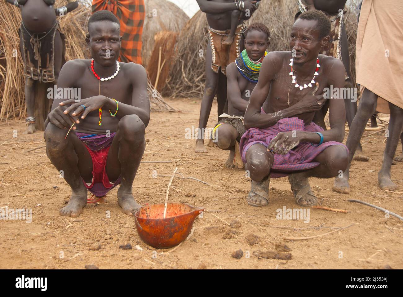 Nyangatom (Bumi) Männer Teilen einer Kalebasse Kuh Blut, Omo-Tal, Äthiopien Stockfoto
