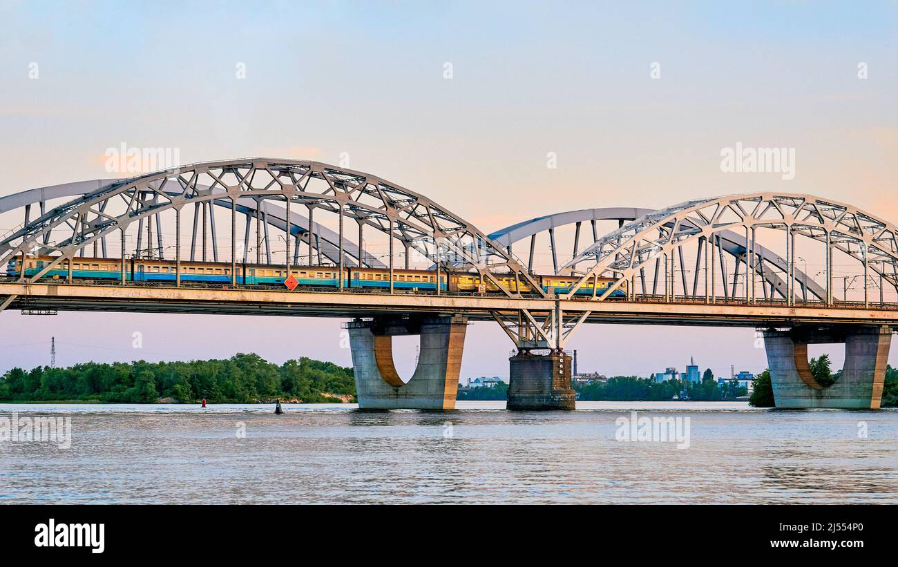 Eisenbahnbrücke über den Fluss mit einem Personenzug Stockfoto