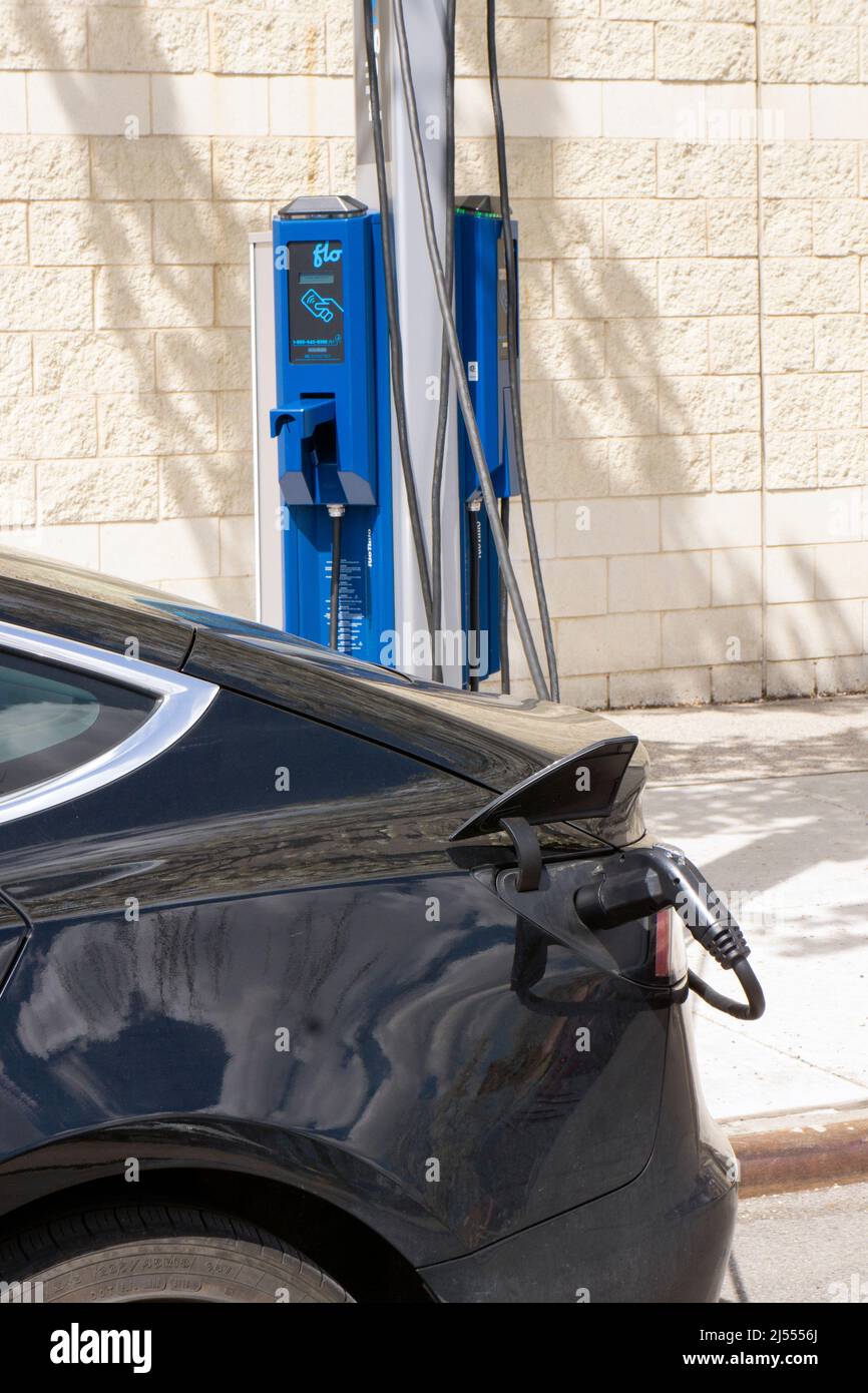 Ein Tesla-Elektroauto lädt seine Batterie an einer FLO-Ladestation in Astoria Queens, New York City. Stockfoto